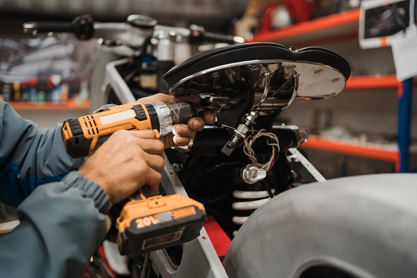 man-fixing-motorcycle-modern-workshop